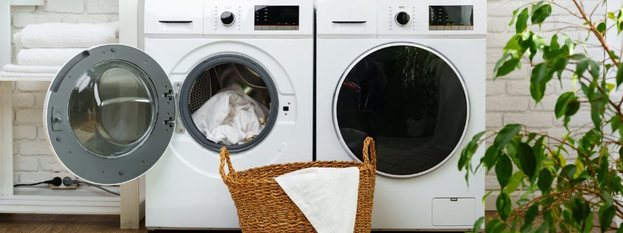 Modern white tumble dryer with open door showing clean dry clothes and lint filter in Cape Town laundry room